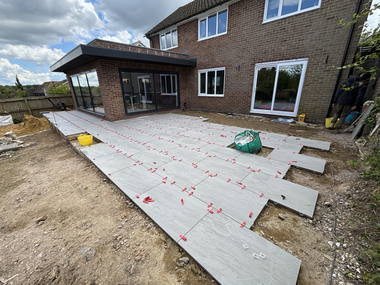 Large paving slabs being laid across the patio