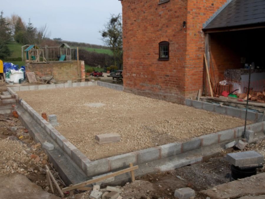 Concrete groundwork beside a brick house